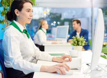 Bank teller at desk assisting customers. Financial services professional at work.